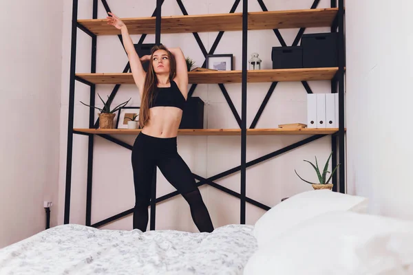 Atractivo fitness mujer haciendo ejercicios de estiramiento en casa, como parte de un estilo de vida saludable sin ir al gimnasio . — Foto de Stock