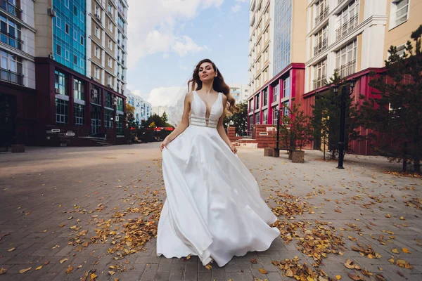 Novia posando en un parque verde chica en un vestido blanco sobre un fondo de verde . — Foto de Stock