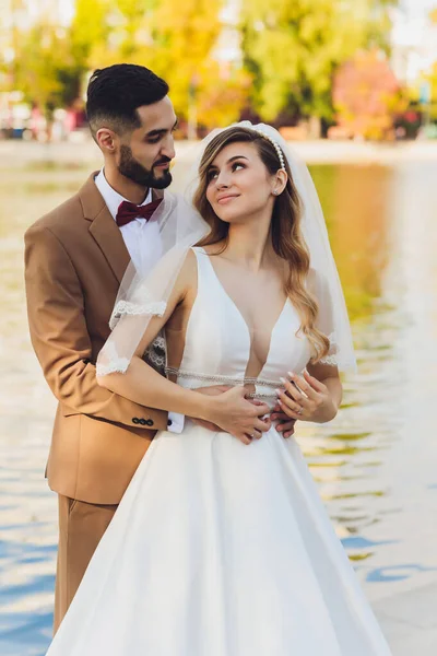 Şık mutlu gelin ve damat açık havada düğün resepsiyonda akşam ışığında büyük aşk kelime poz. Akşam parkında eğlenmek yeni evlilerin Muhteşem düğün çift.