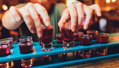 Barmen rom ve likörle alkollü shot yapar..