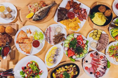 Lezzetli salamlı yemek tepsisi, dilimlenmiş jambon, sosis ve salata. Masada seçili et tabağı.