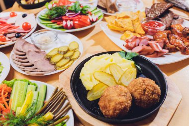 Çeşitli abur cubur ve salatalarla dolu yemek masası. Somon, zeytin, şarap, sebze, ızgara balık tostu. Aile yemeği konsepti. Şükran Günü, Noel. Üst veiw.