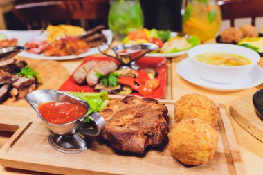 Çeşitli abur cubur ve salatalarla dolu yemek masası. Somon, zeytin, şarap, sebze, ızgara balık tostu. Aile yemeği konsepti. Şükran Günü, Noel. Üst veiw.