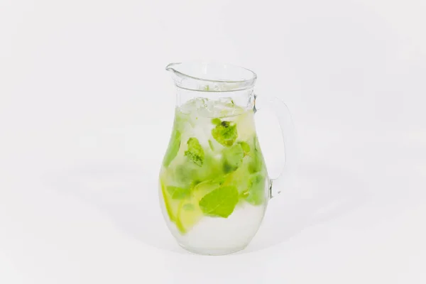 Frische Limonade mit Limetten und Eiswürfeln in einem zuckerumrandeten Glas auf Holz mit Limetten im Rücken auf schwarzem Hintergrund sehr flache Schärfentiefe, Fokus auf das Glas im Rücken und die Limettenscheibe davor. — Stockfoto