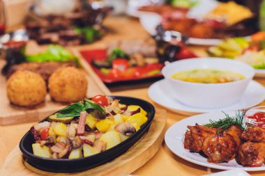 Akşam yemeği parti gıda kavramı. Izgara sosis ile yemek masası, tortilla saran, bira içmek ve ahşap masa, rustik tarzı üzerinde farklı yemekler.