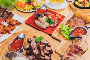 Çeşitli abur cubur ve salatalarla dolu yemek masası. Somon, zeytin, şarap, sebze, ızgara balık tostu. Aile yemeği konsepti. Şükran Günü, Noel. Üst veiw.