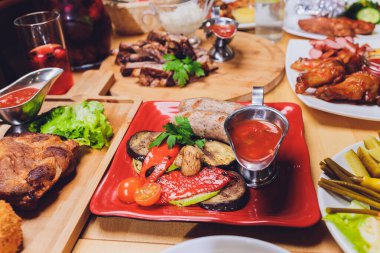 Çeşitli abur cubur ve salatalarla dolu yemek masası. Somon, zeytin, şarap, sebze, ızgara balık tostu. Aile yemeği konsepti. Şükran Günü, Noel. Üst veiw.