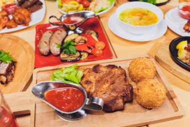Çeşitli abur cubur ve salatalarla dolu yemek masası. Somon, zeytin, şarap, sebze, ızgara balık tostu. Aile yemeği konsepti. Şükran Günü, Noel. Üst veiw.