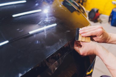 Şeffaf film, araba boyası koruması, ambalaj spesiyali. Araba tamiri. Seçici odak.