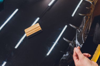 Şeffaf film, araba boyası koruması, ambalaj spesiyali. Araba tamiri. Seçici odak.