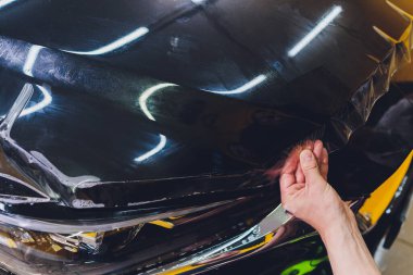 Şeffaf film, araba boyası koruması, ambalaj spesiyali. Araba tamiri. Seçici odak.