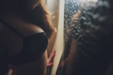 Siyah arka planda yükselen bir kadın göğsü.