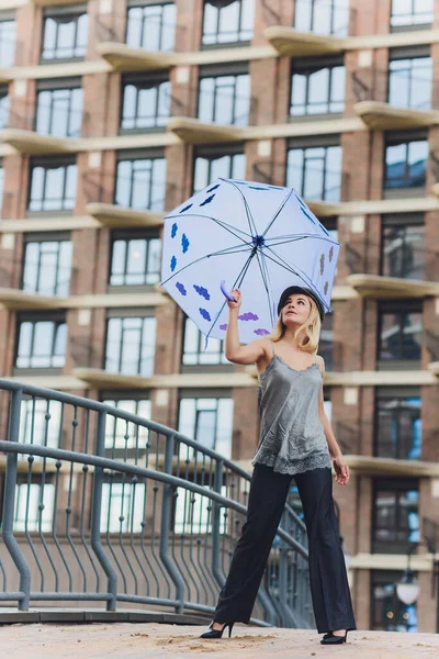 Dívka s deštníkem pobíhající po ulici v deštivém dni. — Stock fotografie