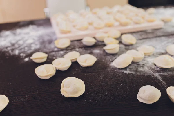 Oberedda dumplings på svart bakgrund, mjöl, valstråd, sked, platt låg, horisontellt. — Stockfoto