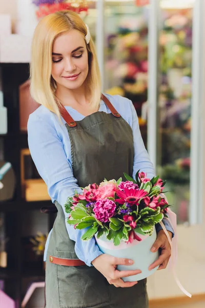 Assistente de vendas feminino trabalhando como florista e segurando buquê com o cliente em segundo plano. Forma horizontal, cintura para cima . — Fotografia de Stock