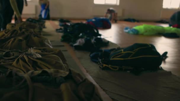 De nombreux parachutes ouverts en attente d'être pliés. — Video