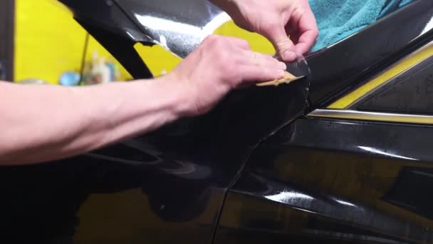 Filme transparente, proteção de pintura de carro, embrulhando specialis. Detalhes do carro. Foco seletivo . — Vídeo de Stock