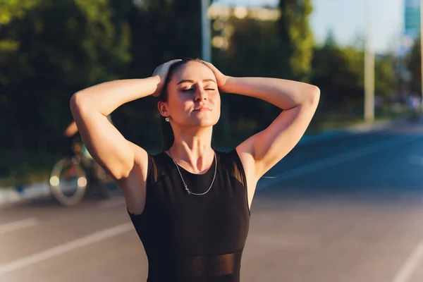 Müder Läufer schwitzt, nachdem er hart auf der Landstraße gelaufen ist. Erschöpfte, verschwitzte Frau nach Marathontraining an heißen Sommertagen. Spanisch brünette Sportlerin im Freien. — Stockfoto