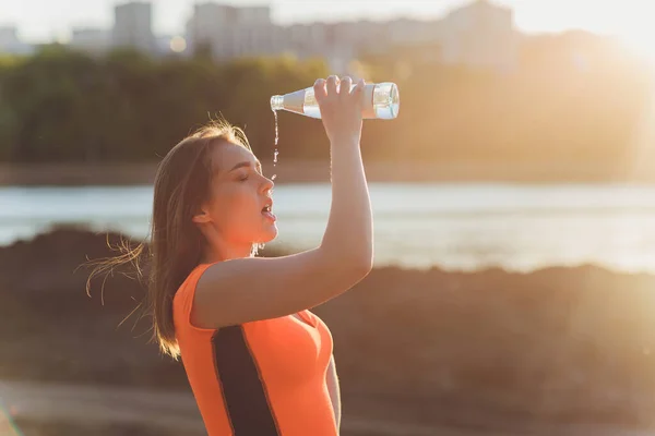 훈련 후에 물을 마시는 날씬 한 젊은 여자. — 스톡 사진