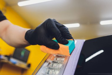 Araba temizleme - Adam arabaya nano koruyucu kaplama uyguluyor. Seçici odak.