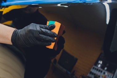 Araba temizleme - Adam arabaya nano koruyucu kaplama uyguluyor. Seçici odak.