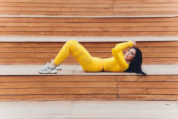 Mujer joven en ropa deportiva se está calentando y estirando en el paseo marítimo. Estilo de vida, Actividad, Salud. — Foto de Stock