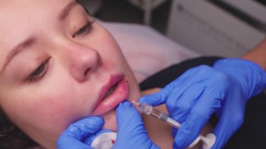 Genç bir kadın dudaklarına iğne vuruluyor, kapatın..