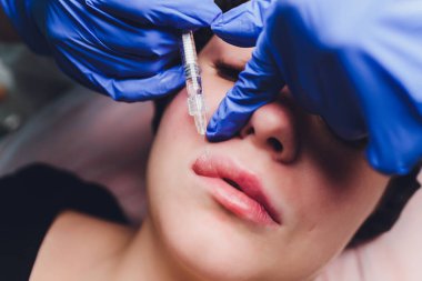 Genç bir kadın dudaklarına iğne vuruluyor, kapatın..