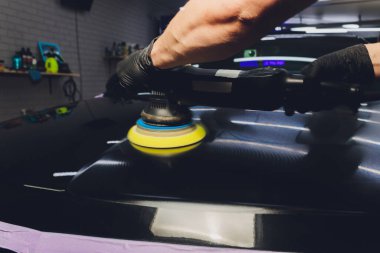 Araba tamiri, oto tamirhanesinde orbital parlatıcıyla el işi. Seçici odak.