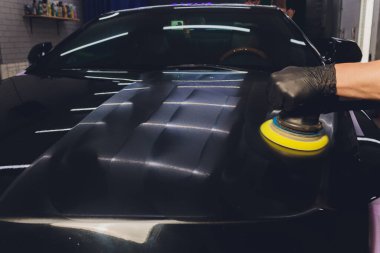 Araba tamiri, oto tamirhanesinde orbital parlatıcıyla el işi. Seçici odak.