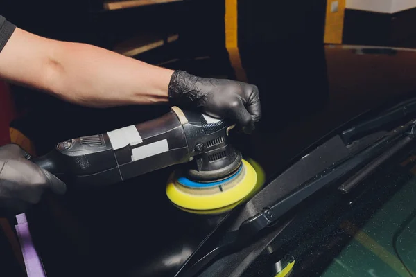 Car detailing - Χέρια με τροχιακό γυαλιστικό σε συνεργείο αυτοκινήτων. Επιλεκτική εστίαση. — Φωτογραφία Αρχείου