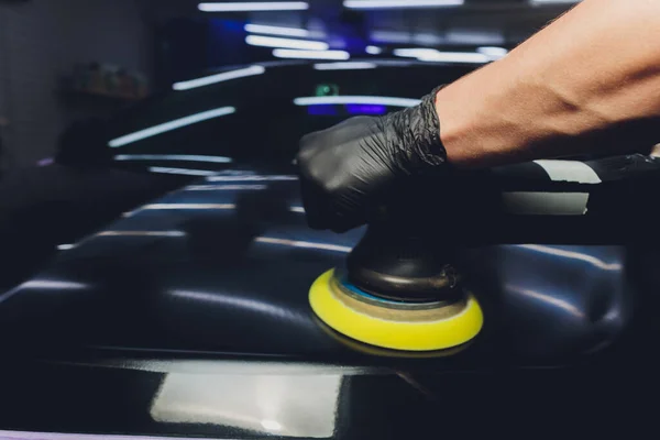 Car detailing - Χέρια με τροχιακό γυαλιστικό σε συνεργείο αυτοκινήτων. Επιλεκτική εστίαση. — Φωτογραφία Αρχείου