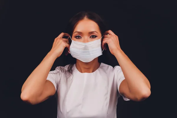 Kapalı kadın portresi, enfeksiyon, hastalık, grip ve 2019-NCoV 'u önlemek için ev yapımı hijyenik yüz maskesi takan genç bir kadın. Siyah arka plan. Hastalıklara ve koronavirüse karşı koruma. — Stok fotoğraf