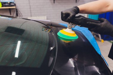 Araba tamiri, oto tamirhanesinde orbital parlatıcıyla el işi. Seçici odak.