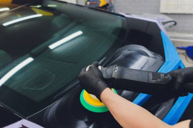 Araba tamiri, oto tamirhanesinde orbital parlatıcıyla el işi. Seçici odak.