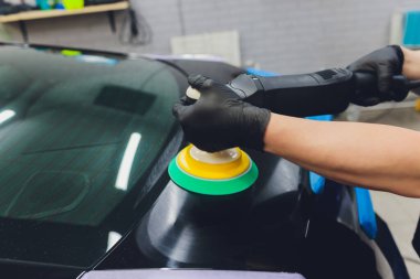 Araba tamiri, oto tamirhanesinde orbital parlatıcıyla el işi. Seçici odak.