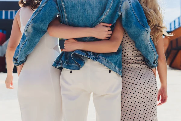 Şehir caddesinde birlikte yürüyen yakın erkek ve kadın arkadaşlar. Dışarda yürüyen ve birbirlerine sarılan melez insanların arka görüntüsü. Arkadaşlık ve destek kavramı.