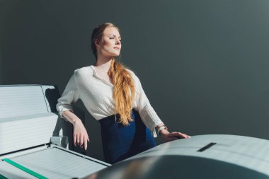 Matbaada çalışan genç bir kadın. Yazdırma Basını.