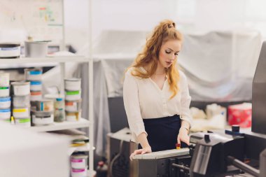 Matbaada çalışan genç bir kadın. Yazdırma Basını.