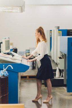 Matbaada çalışan genç bir kadın. Yazdırma Basını.