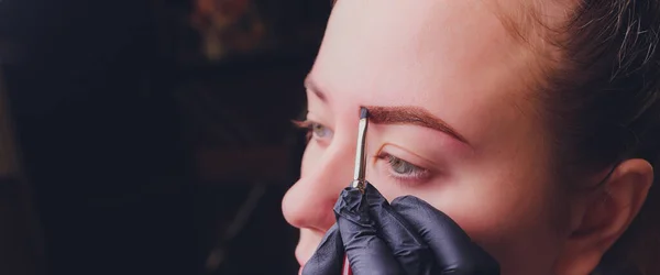 화장하기. Beauticiality Hands Doing Eyebrow Tattoo On Woman Face.Permanent Brow Makeup In Beauty Salon. 특수 요원 이 여성을 위해에 이브루 타투 잉을 하고 있습니다. 우주 생물 치료. — 스톡 사진