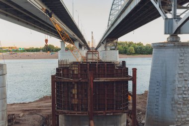 Bitmemiş beton yapı kısmen yeni inşaat alanında mavi branda ile kaplı.