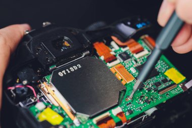 Mühendis ve teknisyen Minitures kamera ayna kutusu montajını tamir ediyor, Miniture çalışanları optikleri kontrol ediyor ve servis merkezindeki bozuk kameranın bakımını ve temizliğini yapıyorlar..