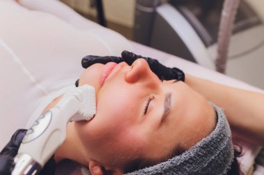 Lenfatik drenaj masajı LPG aygıtı işlemi. Terapist güzellik uzmanı güzellik salonunda manken için canlandırıcı bir yüz masajı yapıyor. Yaklaş, seçici odaklanma.