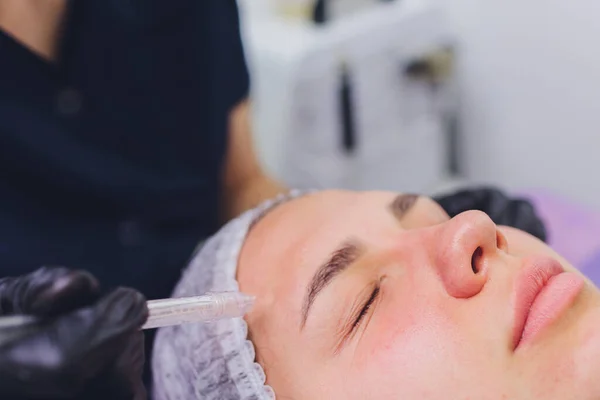 Donna che pulisce i pori della pelle del naso usando aspirapolvere, procedura cosmetica. — Foto Stock