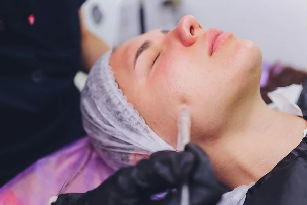 Mujer limpiando poros de la piel de la nariz usando removedor de cabeza negra de vacío, procedimiento cosmético. — Foto de Stock