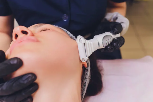 Proceso de drenaje linfático masaje GLP aparato. La esteticista terapeuta hace un masaje facial rejuvenecedor para la modelo en un salón de belleza. Primer plano, enfoque selectivo. — Foto de Stock