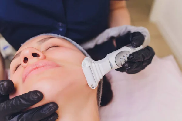 Lymphatic drainage massage LPG apparatus process. Therapist beautician makes a rejuvenating facial massage for the model in a beauty salon. Close up, selective focus.