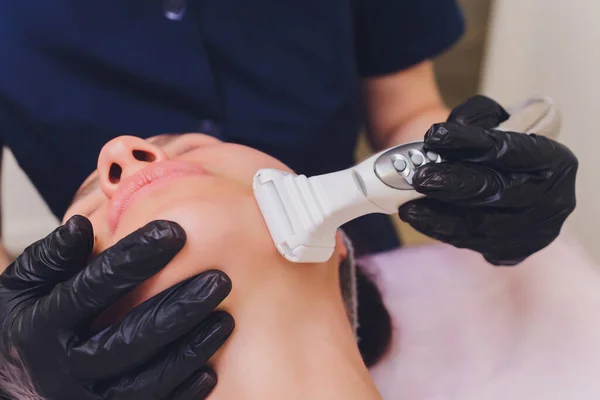 Lymfdränage massage LPG apparat process. Terapeut kosmetolog gör en föryngrande ansiktsmassage för modellen i en skönhetssalong. Närbild, selektivt fokus. — Stockfoto