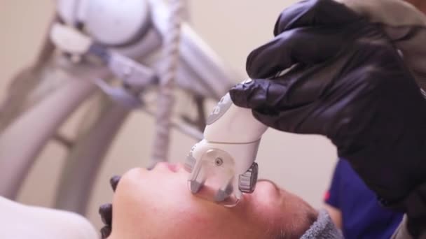 Proces odwadniania limfatycznego urządzenia do masażu gazowego. Terapeuta kosmetyczka robi odmładzający masaż twarzy modelce w salonie piękności. Zbliżenie, wybiórcze skupienie. — Wideo stockowe